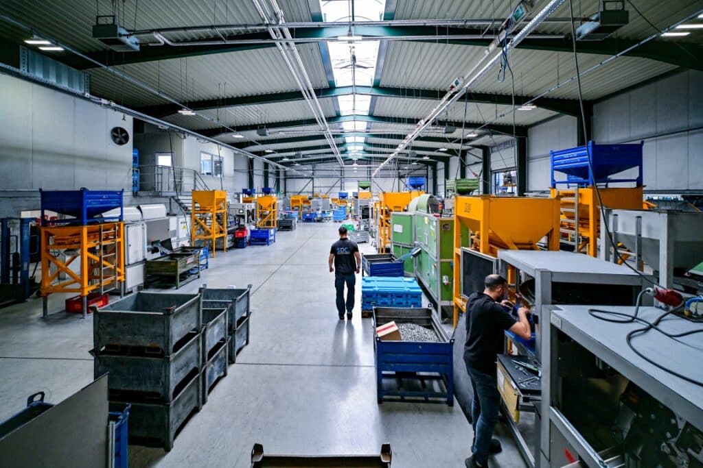 Produktionshalle mit Maschinen und Arbeitern