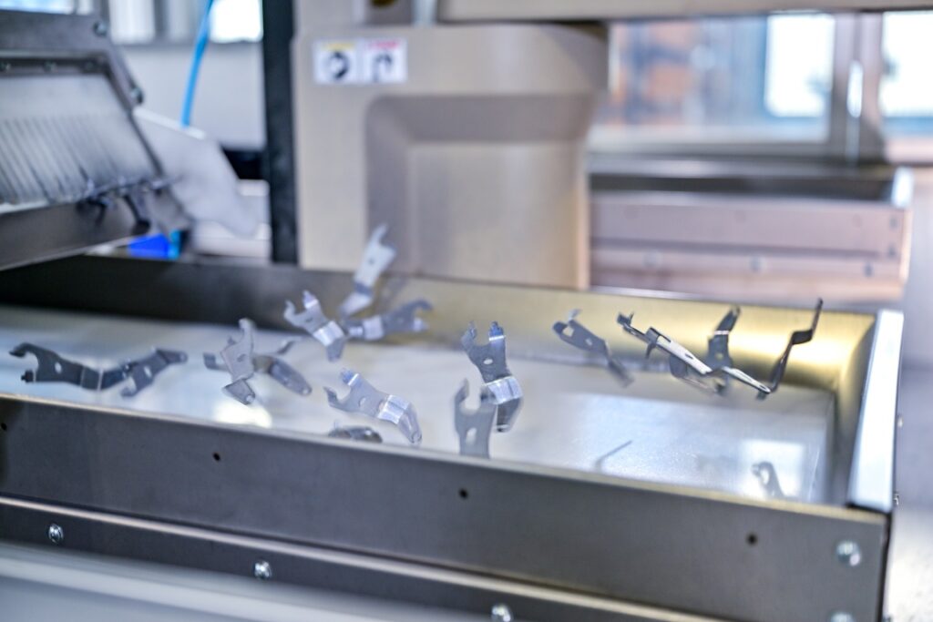 Metallteile auf Förderband in Produktionsmaschine